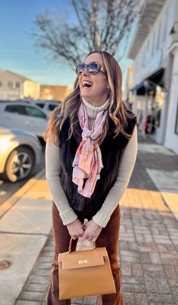 Image of beautiful woman outside laughing on sidewalk while wearing the Designer Shoe Print Scarf tied around her neck.