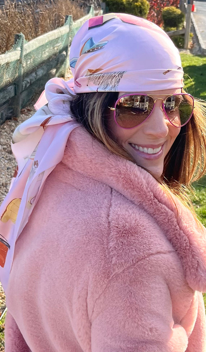 Image of beautiful woman in a fuzzy pink jacket looking over her shoulder with the Designer Shoe Print Scarf tied around her head